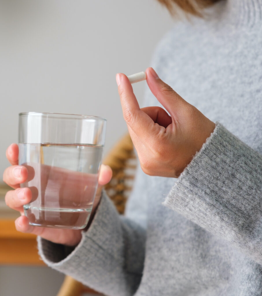 Photo of a woman taking an antibiotic with water