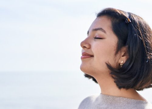 Photo of a woman taking in fresh air at the beach
