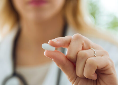 Photo of a doctor holding up a pill